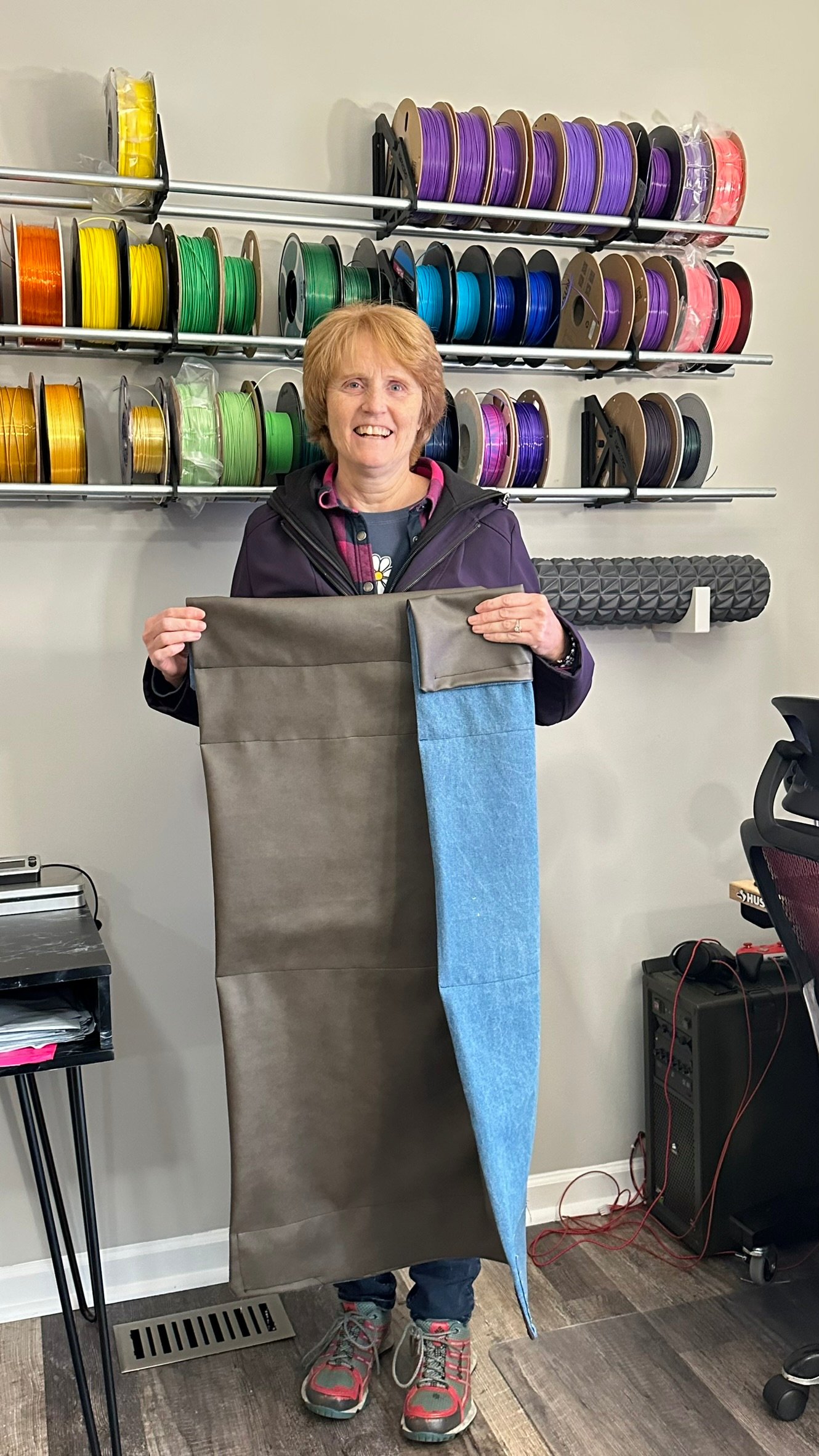 Mom standing in front of the Reprak filament wall with hand-sewn magnetic printer panels